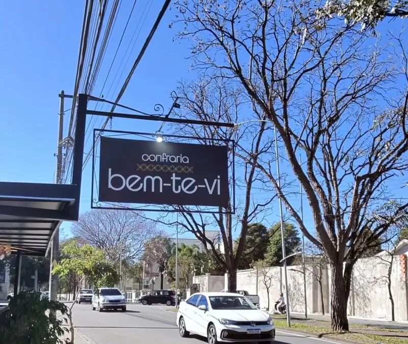 Placa da Confraria Bem Te Vi sob o céu azul de manhã